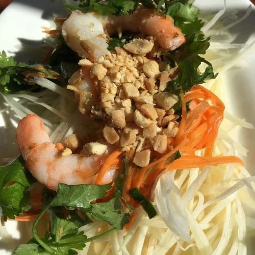 Green Papaya Salad - A refreshing and tangy salad made with shredded green papaya, fresh herbs, peanuts, and a zesty lime dressing. Light, crunchy, and bursting with flavor.